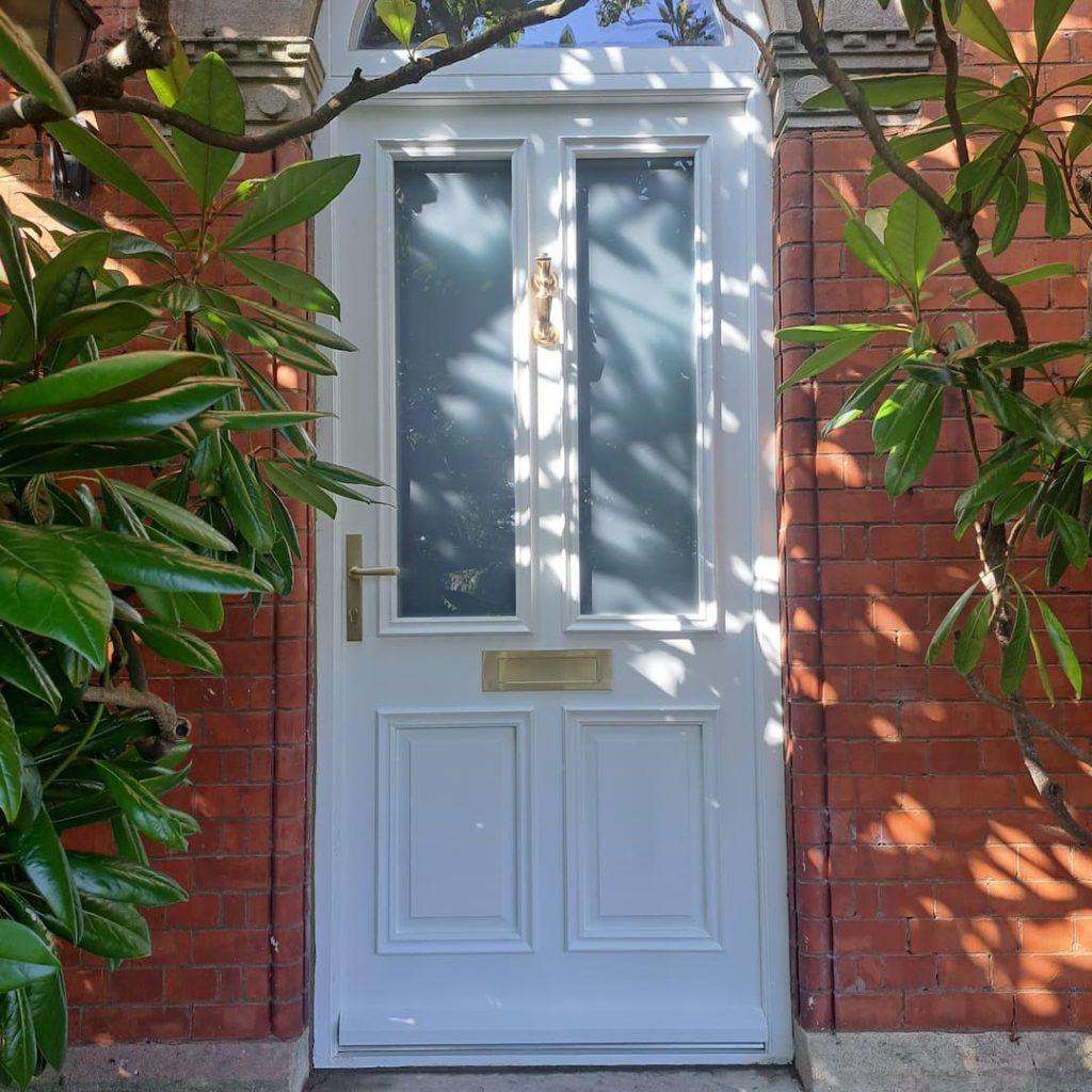 door and brick wall with plants around sides of door
